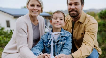 happy family holding plastic model of wind turbine 2022 11 02 02 19 50 utc